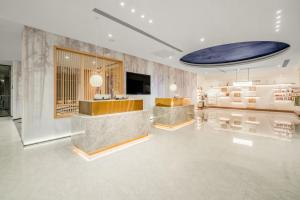 a lobby with a reception desk and a tv in it at Atour X Hotel - Taikoo Li Chengdu in Chengdu