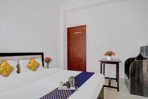 a bedroom with a bed and a wooden door at SPOT ON Hotel Srb in Jodhpur