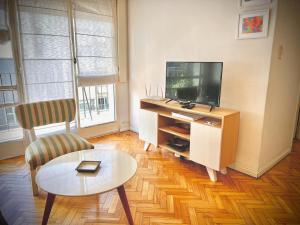 uma sala de estar com uma televisão e uma mesa de centro em Premium Apartments in Barrio Norte by Apartments Bariloche em Buenos Aires