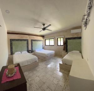 a bedroom with two beds and a ceiling fan at Casa Tulup Sisal in Sisal