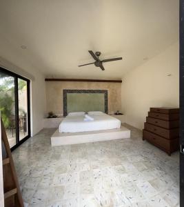 1 dormitorio con 1 cama y ventilador de techo en Casa Tulup Sisal, en Sisal