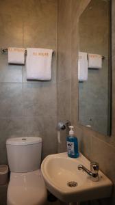ein Badezimmer mit einem WC, einem Waschbecken und einem Spiegel in der Unterkunft El Hogar in Kiambu