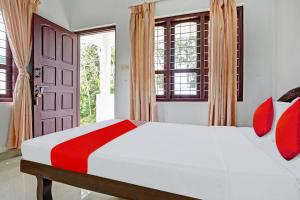 Een bed of bedden in een kamer bij Flagship Mankulam Misty Mountain View