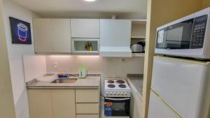 a small kitchen with white cabinets and a microwave at Exclusivo Dpto, Zona Residencial in Godoy Cruz