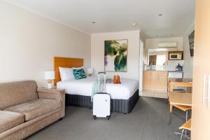 um quarto de hotel com uma cama e um sofá em Tea House Motor Inn em Bendigo