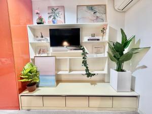 a room with a tv on a shelf with plants at Smart Condominium in Cagayan de Oro City in Cagayan de Oro