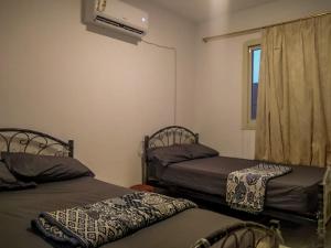 um quarto com duas camas e uma janela e uma televisão em Sea Park Chalet-Stella Di Mare Sea view -Families em Az Za‘faranah