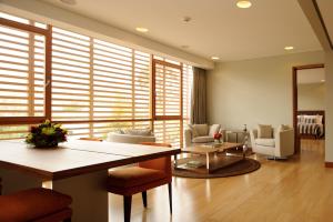 a living room with a table and chairs and windows at NOI Vitacura in Santiago