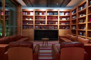 a living room with couches and a tv and shelves at NOI Vitacura in Santiago