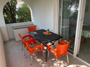 a table and chairs in a room with a window at Apartments MiaMaja in Novalja