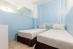 two beds in a room with blue walls at The Quay Hotel Bukit Bintang in Kuala Lumpur