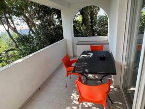 a balcony with a table and chairs and two windows at Apartments MiaMaja in Novalja