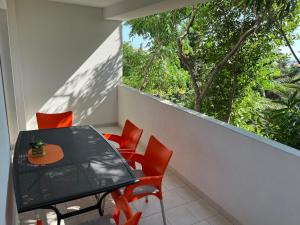 a table and chairs on a balcony with a window at Apartments MiaMaja in Novalja