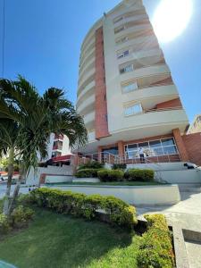 a large building with palm trees in front of it at Lindo apartamento cerca de Centro Comercial unico in Barranquilla