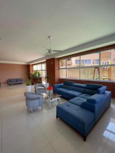a large living room with blue couches and chairs at Lindo apartamento cerca de Centro Comercial unico in Barranquilla