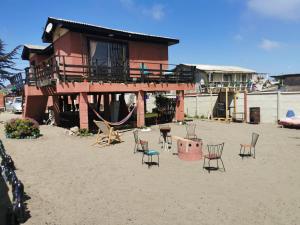 budynek z krzesłami i placem zabaw na piasku w obiekcie Arriendo casa vista al mar w mieście Las Cruces