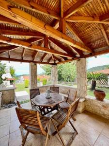 a wooden table and chairs under a wooden roof at #ALS- Stone Maisonette in Paliouri in Paliouri