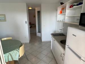a small kitchen with a table and a sink at Apartments MiaMaja in Novalja