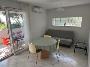 a living room with a table and a couch at Apartments MiaMaja in Novalja