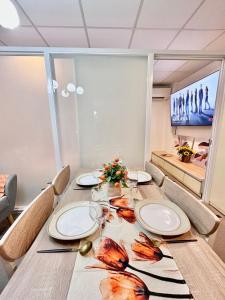 a dining room table with plates and wine glasses at 3 Smart Condominium in Cagayan de Oro City in Cagayan de Oro