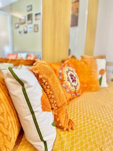 a bed with orange and white pillows on it at 3 Smart Condominium in Cagayan de Oro City in Cagayan de Oro