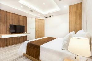 a bedroom with a bed and a flat screen tv at SEA APARTHOTEL in Ho Chi Minh City