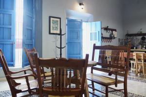 ein Esszimmer mit blauen Türen sowie einem Tisch und Stühlen in der Unterkunft Habitacion Azul / Casa del Café in Campeche