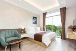 a hotel room with a bed and a chair at SEA APARTHOTEL in Ho Chi Minh City