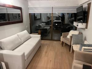 uma sala de estar com um sofá branco e cadeiras em Ski in-out Apartment in El Colorado em El Colorado