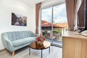 a living room with a couch and a large window at SEA APARTHOTEL in Ho Chi Minh City