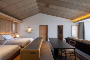a bedroom with two beds and a desk in it at アルカディアリゾート宮古島 in Irabu