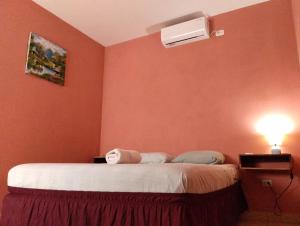 a bedroom with a bed and a air conditioner on the wall at Hotel Munch in Managua