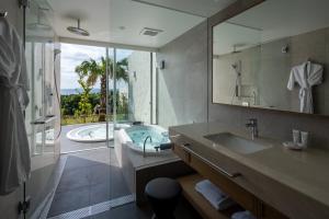 a bathroom with a tub and a sink and a mirror at アルカディアリゾート宮古島 in Irabu +33 photos