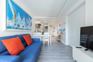 een woonkamer met een blauwe bank en een tv bij Appartement 6 couchages dans résidence avec piscine in Juan-les-Pins