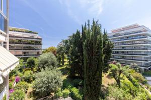 uitzicht op een park met bomen en gebouwen bij Appartement 6 couchages dans résidence avec piscine in Juan-les-Pins