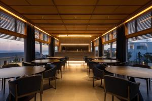 a restaurant with tables and chairs and windows at アルカディアリゾート宮古島 in Irabu