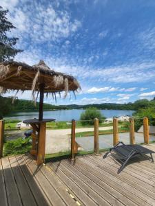 a wooden deck with a table and a straw umbrella at Villa Solina in Zawóz