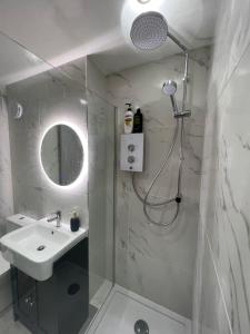 Un baño blanco con ducha y lavabo. en The Raven's Loft by Harry Potter, en Garston 4 fotos más