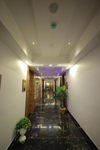 a hallway with potted plants in a building at HOTEL RK FORTUNE in Ahmedabad