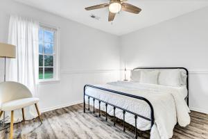 a white bedroom with a bed and a ceiling fan at Quiet escape in Wilmington in Wilmington