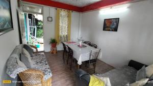 - un salon avec une table et un canapé dans l'établissement Holidays homestay, à Mirik