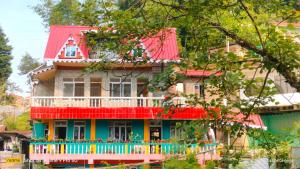 une maison colorée avec un toit rouge dans l'établissement Holidays homestay, à Mirik