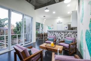 a living room with purple chairs and a table at Ohana Retreat Bali in Mengwi