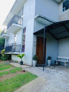 a white house with a wooden door and a bench at kandy hill villa in Kandy