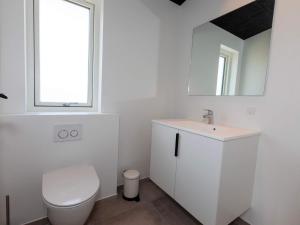 a white bathroom with a toilet and a sink at 10 person holiday home in Saltum-By Traum in Saltum +23 photos