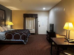 ein Hotelzimmer mit einem Bett und einem TV in der Unterkunft Super 8 by Wyndham Center in Center
