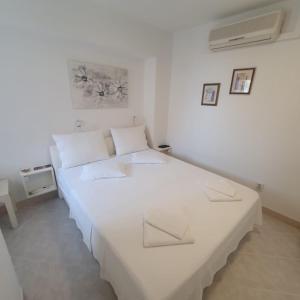 Habitación blanca con 2 camas. en Rooms Garden - with a view, en Dubrovnik