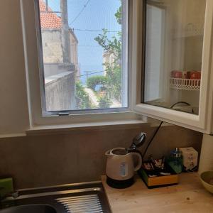 encimera de cocina con ventana sobre un fregadero en Rooms Garden - with a view, en Dubrovnik
