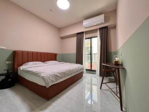 um quarto com uma cama grande e uma janela em T-HOUSE em Taitung City