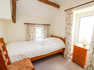 a bedroom with a bed and a window at Llety'r Wennol in Llanycrwys